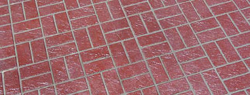 Red Basket Weave concrete overlay with pairs of textured brick shapes alternating horizontally and vertically, separated by gray joints.