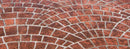 Reddish-brown Cobble Fan concrete overlay with overlapping curved cobblestone patterns and light gray joint lines