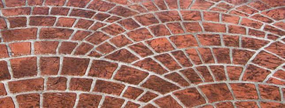 Reddish-brown Cobble Fan concrete overlay with overlapping curved cobblestone patterns and light gray joint lines
