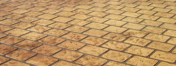 Tan cobble stone pattern concrete overlay with rounded rectangular stone shapes in staggered rows and dark joint lines