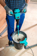 Worker using a Collomix Xo 1 R paddle mixer to mix material in a bucket