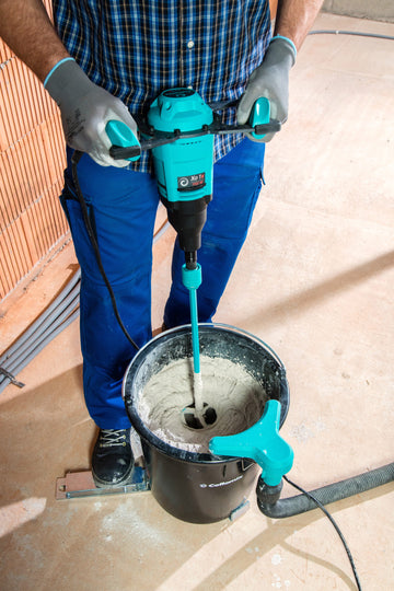 Worker using a Collomix Xo 1 R paddle mixer to mix material in a bucket