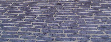 Gray English Cobble concrete overlay with elongated irregular stone shapes in staggered rows and light joint lines
