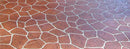 Close-up of reddish-brown flagstone-pattern concrete overlay with light grout lines