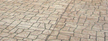 Keystone-pattern concrete overlay with irregular tan stone shapes and dark grout lines