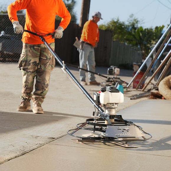 Worker operating a Tomahawk portable power trowel on fresh concrete