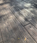 Wood-plank stamped concrete with textured grain and staggered plank joints